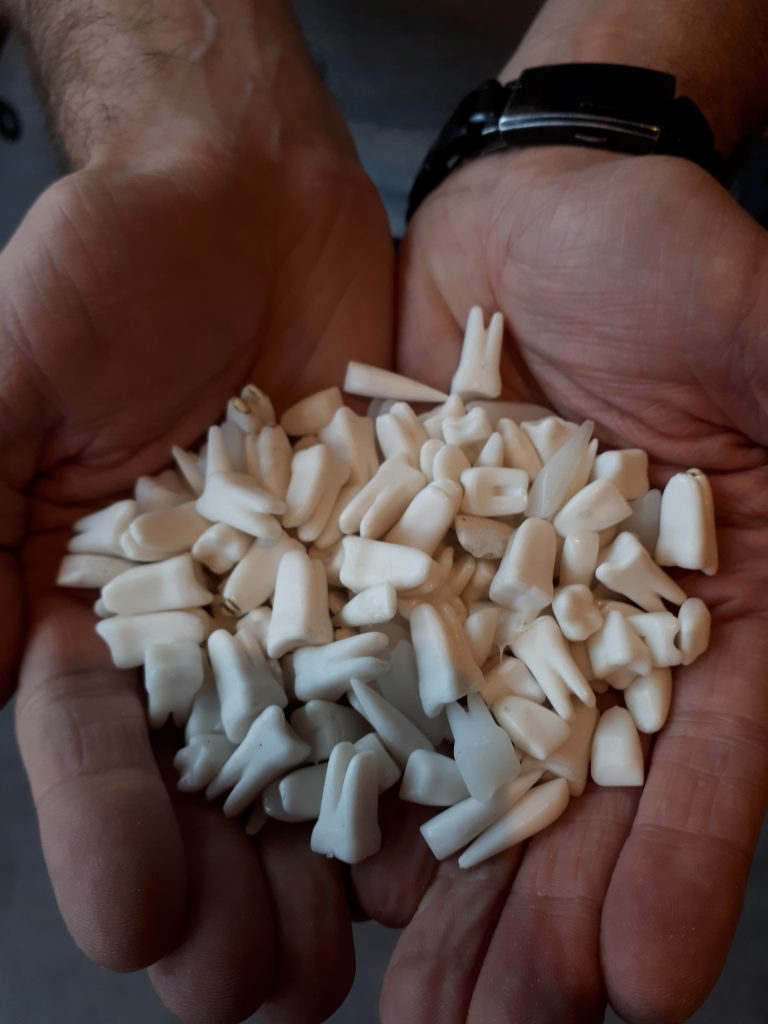 A Foley recordist displays a loose handful of cupped plastic teeth.